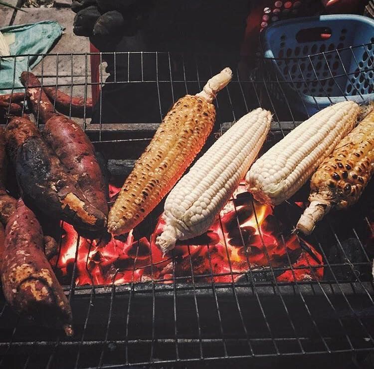 Grilled corn and sweet potatoes on a charcoal stove