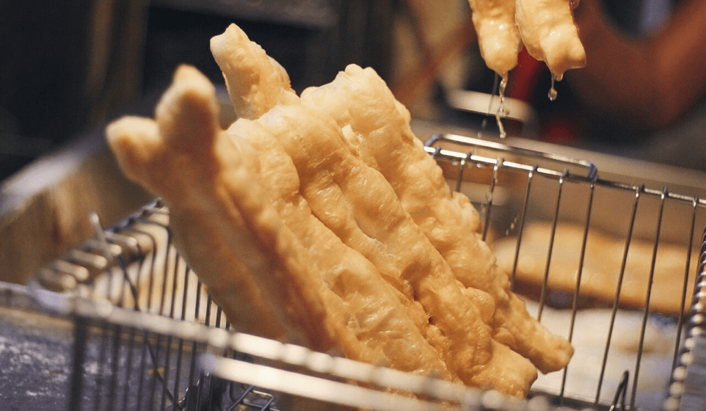 Fried breadsticks dipped in sweet and sour fish sauce for a perfect snack, top